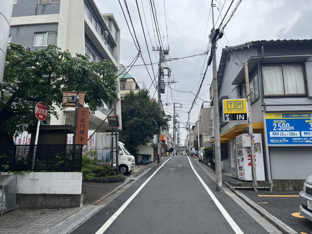 7.住宅街をしばらく進みますとパーキングと左側にお寺の入り口がありお寺側の隣の隣の建物です